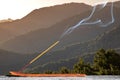 Burning stick of incense stands on a wooden stand on the background of the sunrise in the mountains Royalty Free Stock Photo