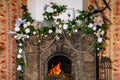 Burning stone fireplace decorated for Christmas.