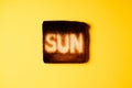 Burning sun. burnt slices of white bread toast with the word Sun on it on yellow background.