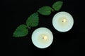 White burning tealight candles on black background. Beauty, SPA treatments, massage therapy and relax concept Royalty Free Stock Photo