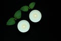 White burning tealight candles on black background. Beauty, SPA treatments, massage therapy and relax concept Royalty Free Stock Photo