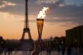Burning torch in a hand of athlete as a symbol of the Olympic Games in Paris, France, Eiffel tower on background. Olympic games Royalty Free Stock Photo
