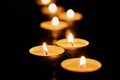 Burning votive candles on dark background Royalty Free Stock Photo