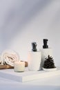 Burning wax candle, towels and soap bottles on white background. Royalty Free Stock Photo