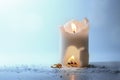 Burning white candle with a flame, campfire in a carve and fire wood outside, surreal concept for heat and energy at home, winter Royalty Free Stock Photo