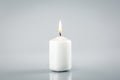 Burning white candle on light grey Royalty Free Stock Photo