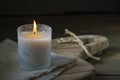 Burning white candle light on old dark wooden table background burlap sack Halloween Aromatherapy smoke rustic cutting board Royalty Free Stock Photo