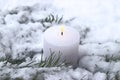 Burning white candle on snow covered coniferous branches Royalty Free Stock Photo