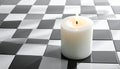 Burning white candle on a wavy black and white tiled surface with light reflections Royalty Free Stock Photo