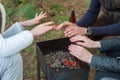 Burning wood in the grill and red coals with stream coming up from it. Little boy in red coat is warming his frozen hands above Royalty Free Stock Photo