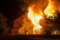 Burning wooden house at night. Bright orange flames and dense sm Royalty Free Stock Photo