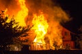 Burning wooden house at night. Bright orange flames and dense sm Royalty Free Stock Photo