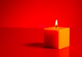 Burning yellow candle over red background