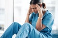 Burnout, stress and medical with nurse on floor of hospital for sad, mental health and headache. Anxiety, depression and Royalty Free Stock Photo