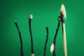 Burnt and bent matchsticks. Wooden matchsticks burning in on a green background. Selective Focus Royalty Free Stock Photo