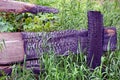 Burnt boards of a wooden fence in green grass and vegetation Royalty Free Stock Photo