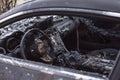 Burnt car close-up. Steering wheel and dashboard. Car after the fire. Arson car. Accident on the road due to speeding. Explosion. Royalty Free Stock Photo