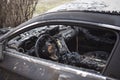 Burnt car interior close-up. Steering wheel and dashboard. Car after the fire. Car wreck burned by vandals or after explosion. Car