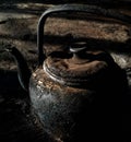 a burnt and dirty iron teapot