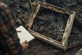 burnt frame in the aftermath of fire, observer with notepad