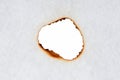 burnt holes in a piece of paper on white background