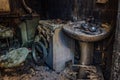 Burnt house interior. Burned burnt bathroom, Fused remains of furniture and washing machine Royalty Free Stock Photo