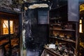 Burnt house interior. Burned furniture, kitchen cabinet, charred walls and ceiling in black soot Royalty Free Stock Photo