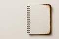 A burnt notebook with lines on a light background. Space for text. Royalty Free Stock Photo
