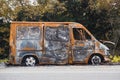 Burnt out big van next to the road. The car after the accident. A burnt-out car without windows and tires Royalty Free Stock Photo