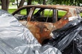 Burnt-out car, side view. Fire completely destroyed the interior of car. Rusty remains of abandoned vehicle Royalty Free Stock Photo