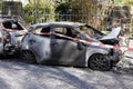 burnt out car wrecks behind police tape in residential street in Germany