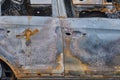 Burnt-out rusty cars on a city street, vandalism. Setting fire to cars by vandals and damage to property Royalty Free Stock Photo