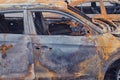 Burnt-out rusty cars on a city street, vandalism. Setting fire to cars by vandals and damage to property Royalty Free Stock Photo