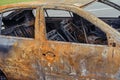 Burnt-out rusty cars on a city street, vandalism. Setting fire to cars by vandals and damage to property Royalty Free Stock Photo