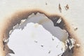 Burnt paper with irregular scorch marks on white surface demonstrating damage and texture Royalty Free Stock Photo