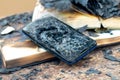 Burnt phone and charred books on the table in the office, traces of fire Royalty Free Stock Photo