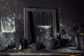 Burnt room interior. Burnt still life. Charred wall, picture frame, pot with burned rose in black soot Royalty Free Stock Photo