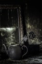 Burnt room interior. Burnt still life. Charred wall, picture frame, pot with burned rose in black soot Royalty Free Stock Photo