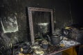 Burnt room interior. Burnt still life. Charred wall, picture frame, pot with burned rose in black soot Royalty Free Stock Photo