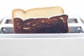 Burnt toast and Bread slices in toaster. Royalty Free Stock Photo