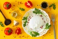 Burrata, Italian cheese with tomatoes, spices, argugula and olive oil and balsamic vinegar / yellow background