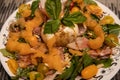 Burrata on top of a salad with cantalope