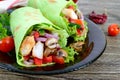 Burrito with chicken, vegetables, mushrooms in pita bread with spinach