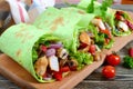 Burrito with chicken, vegetables, mushrooms in pita bread with spinach
