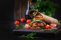 Burritos wraps with beef and vegetables on dark wooden background. Royalty Free Stock Photo