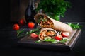 Burritos wraps with beef and vegetables on dark wooden background. Royalty Free Stock Photo