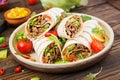 Burritos wraps with beef and vegetables on a wooden background. Royalty Free Stock Photo