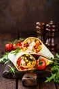 Burritos wraps with chicken meat and vegetables on wooden background