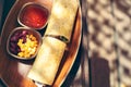 Burritos wraps with meat, beans and vegetables on wood board. Royalty Free Stock Photo