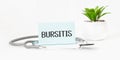 BURSITIS word on notebook,stethoscope and green plant